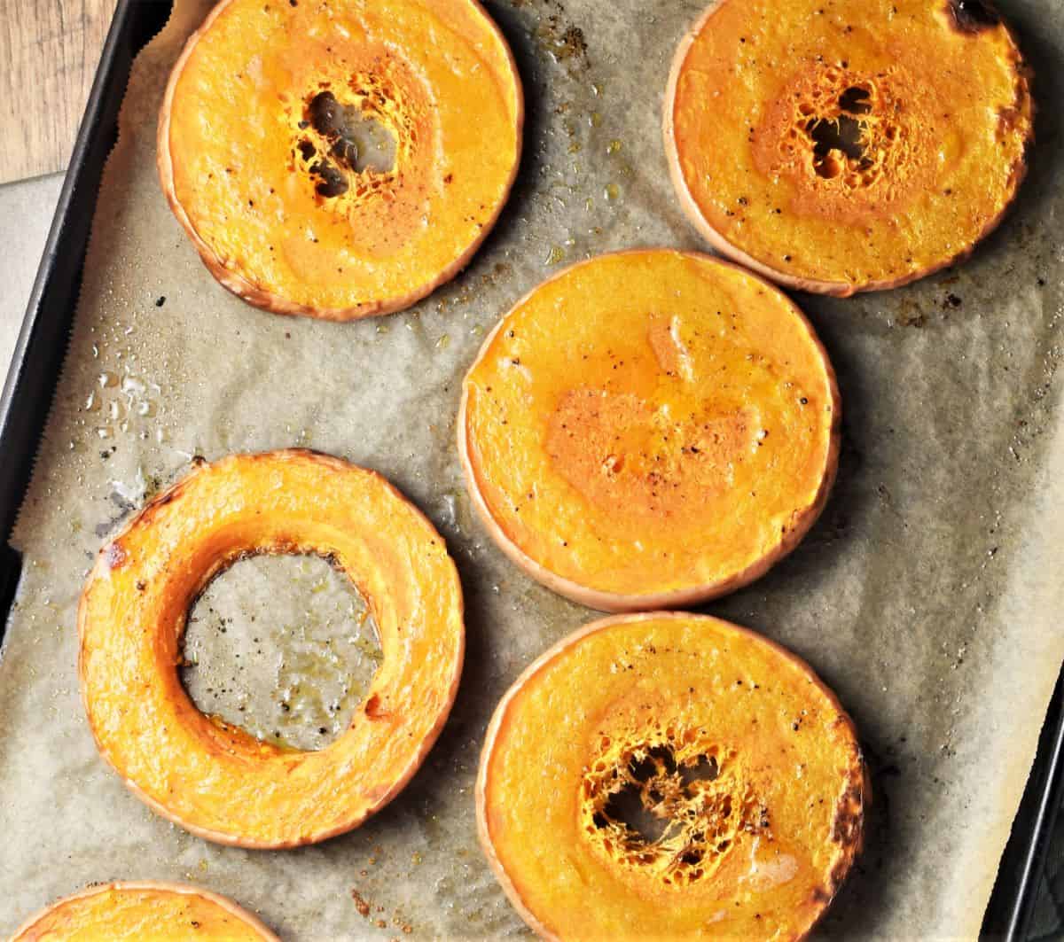 Slices of roasted butternut squash on top of parchment.
