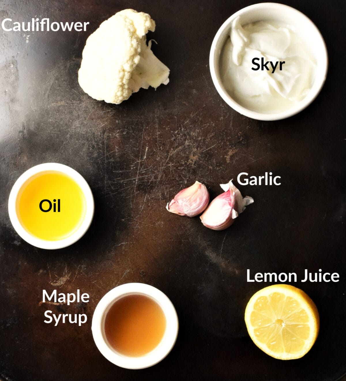 Cauliflower dip ingredients on top of dark surface.
