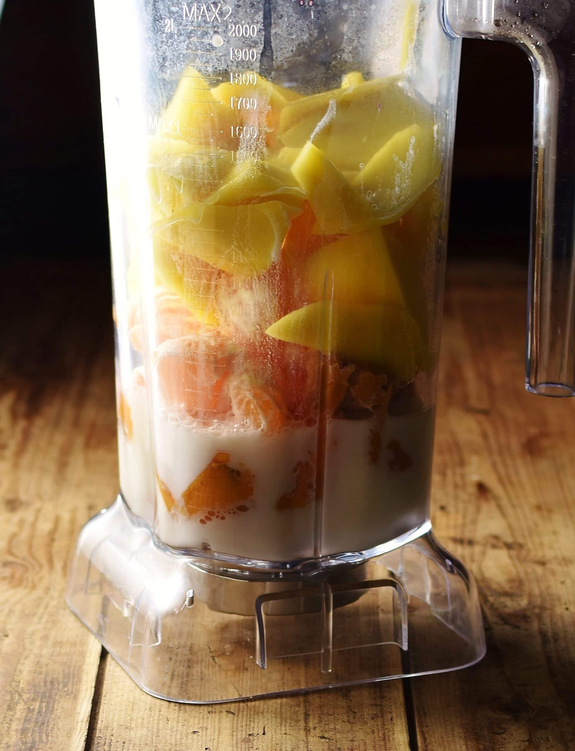 Chopped mango, tangerine, sweet potato and milk in blender.