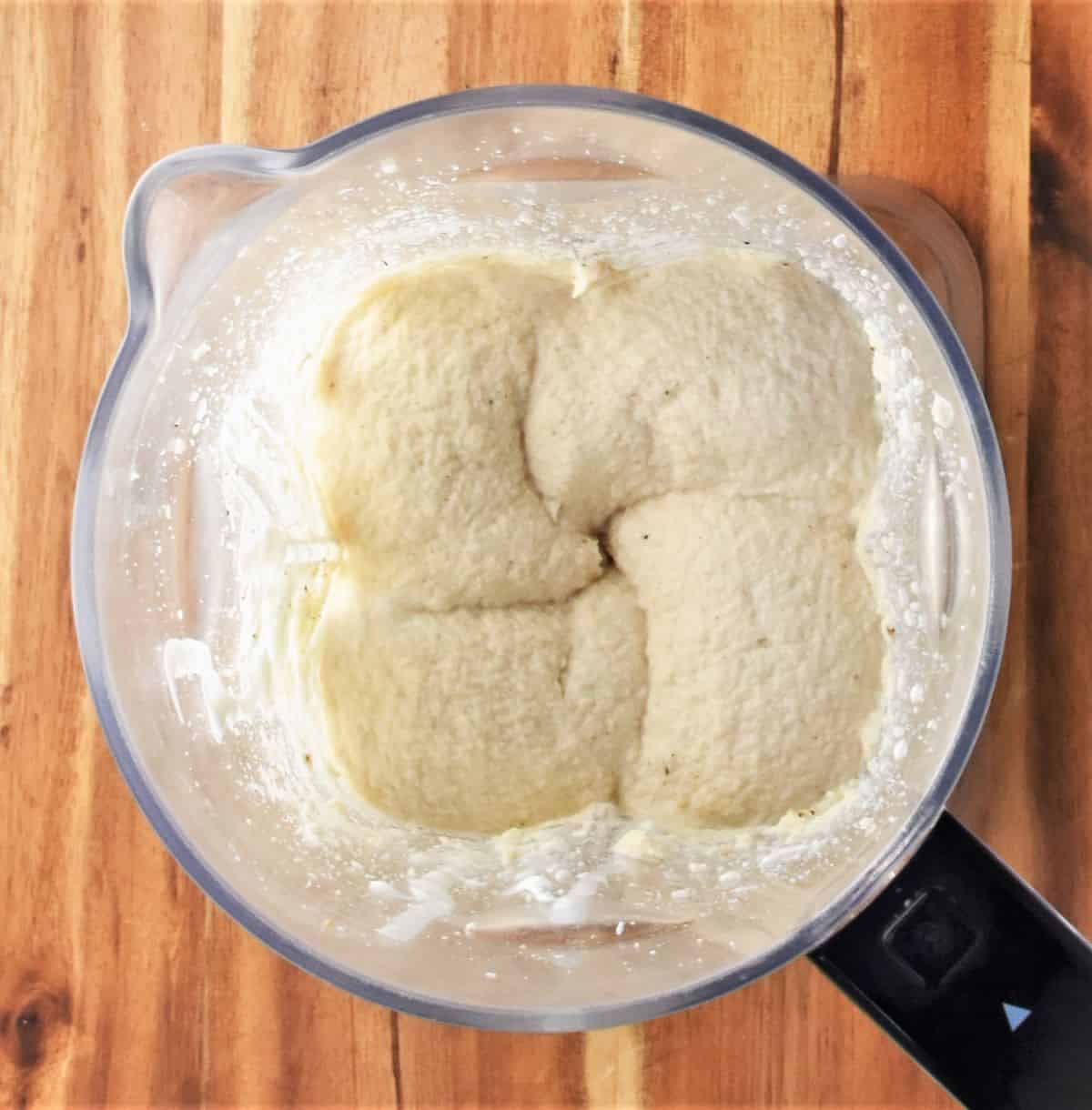 Top down view of creamy pureed cauliflower mixture in blender.