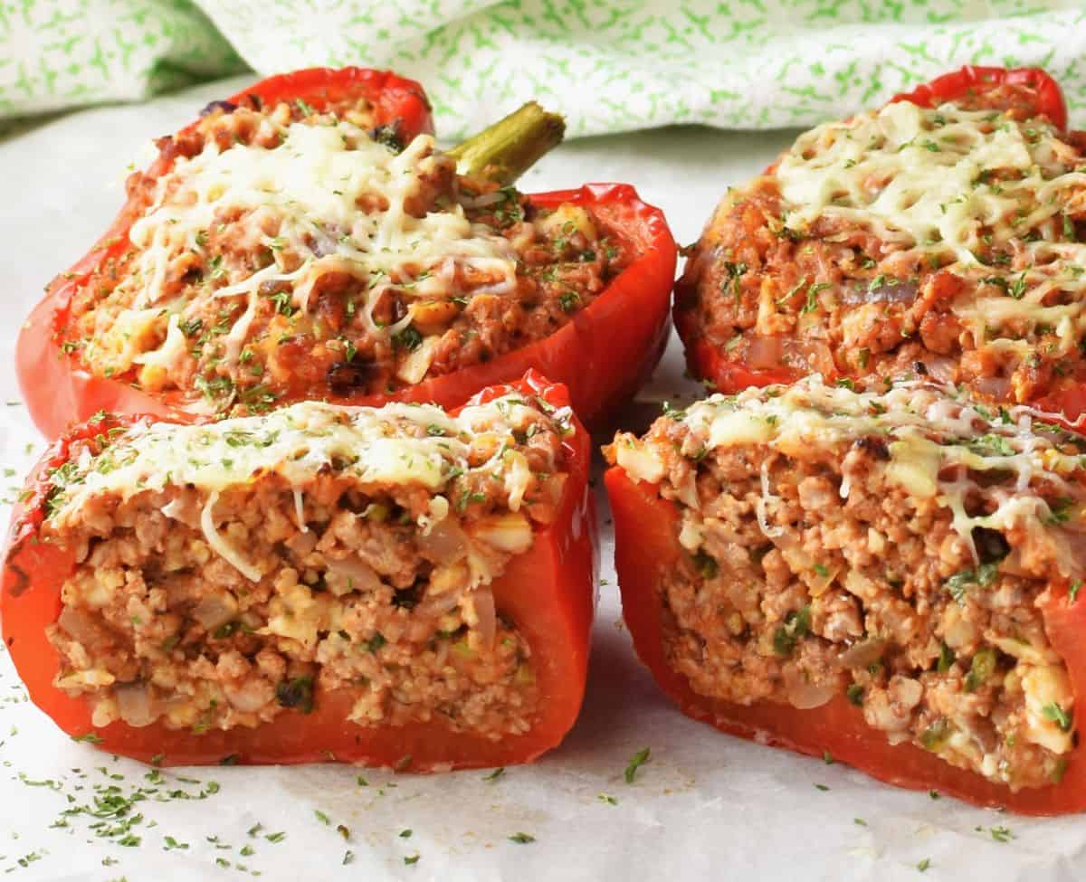 Side view of low-carb stuffed peppers on top of parchment.