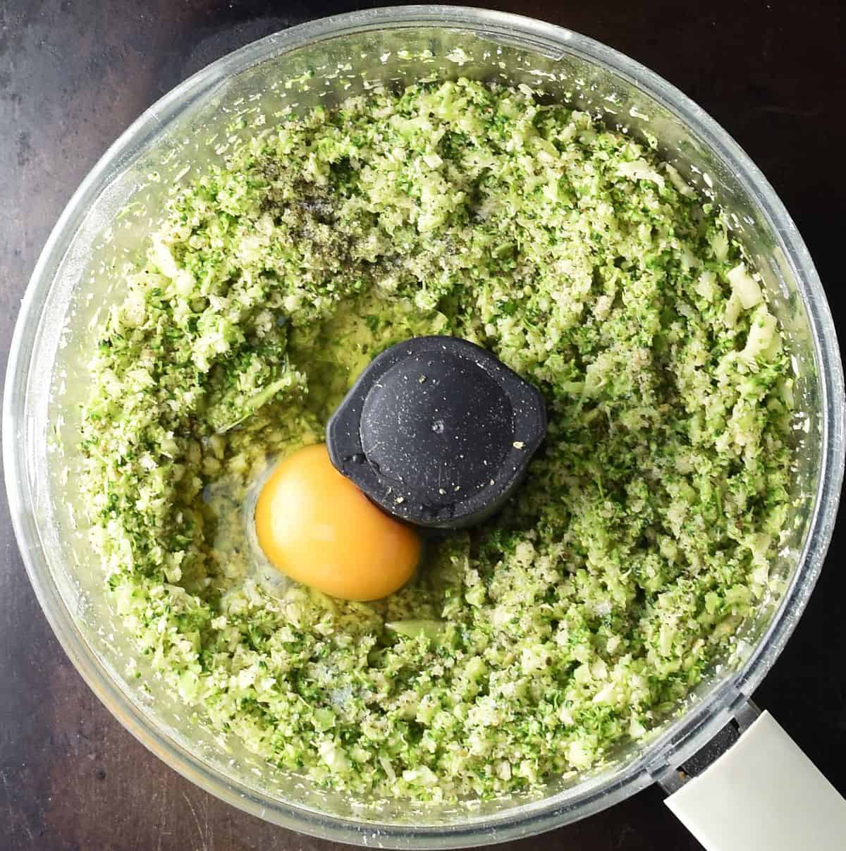 Broccoli patties mixture with raw egg in blender bowl.