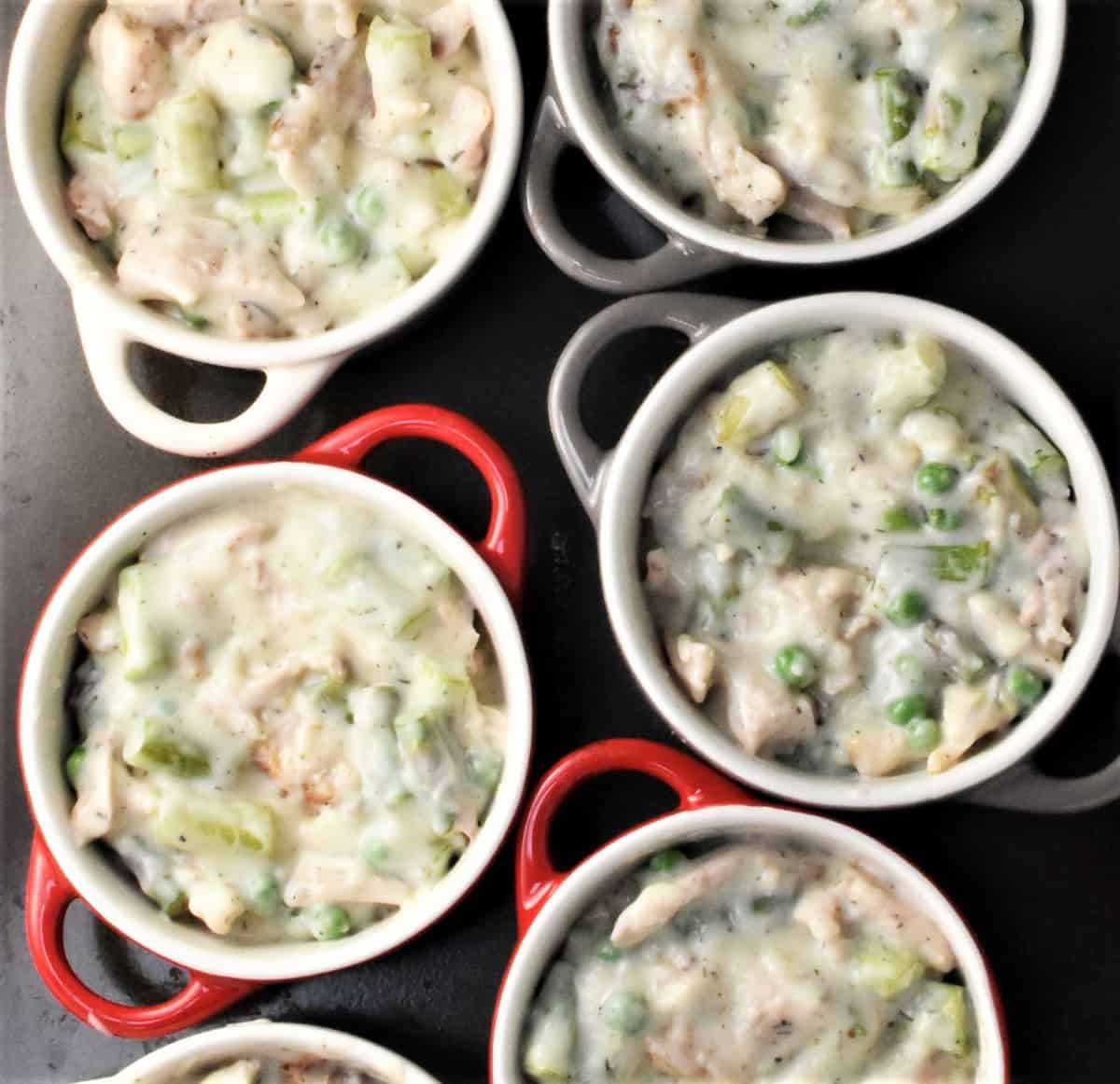 Creamy chicken and asparagus mixture in ramekins.