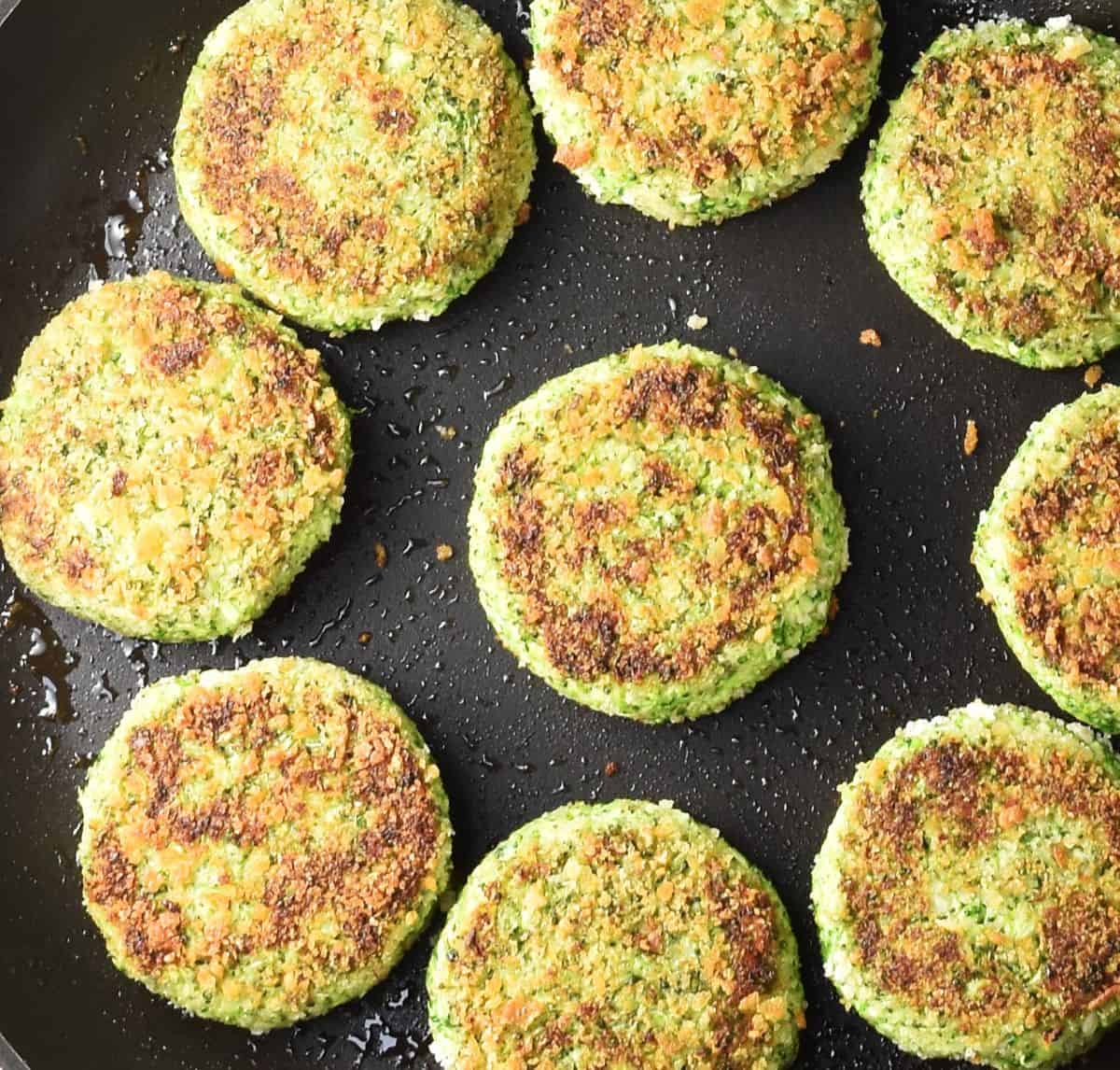 Browned broccoli patties in large shallow pan.