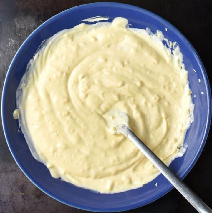 Creamy dressing for salmon egg salad in blue bowl with fork.
