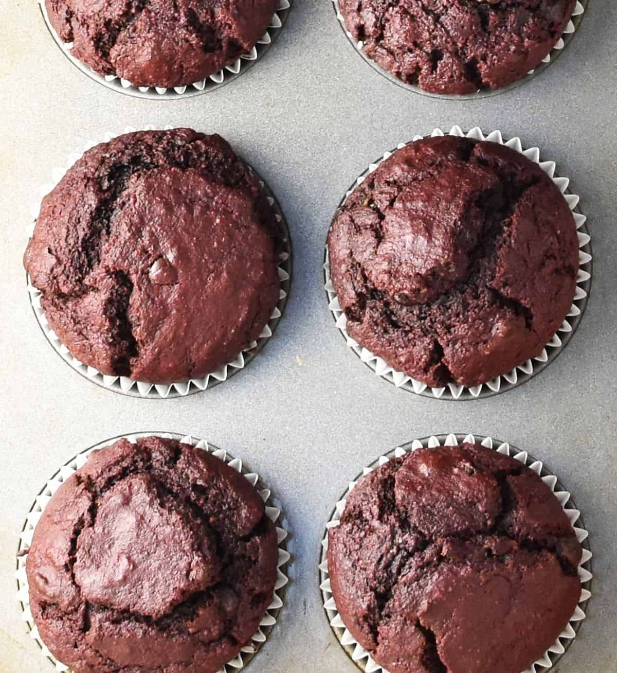 6 baked chocolate beet muffins in pan.