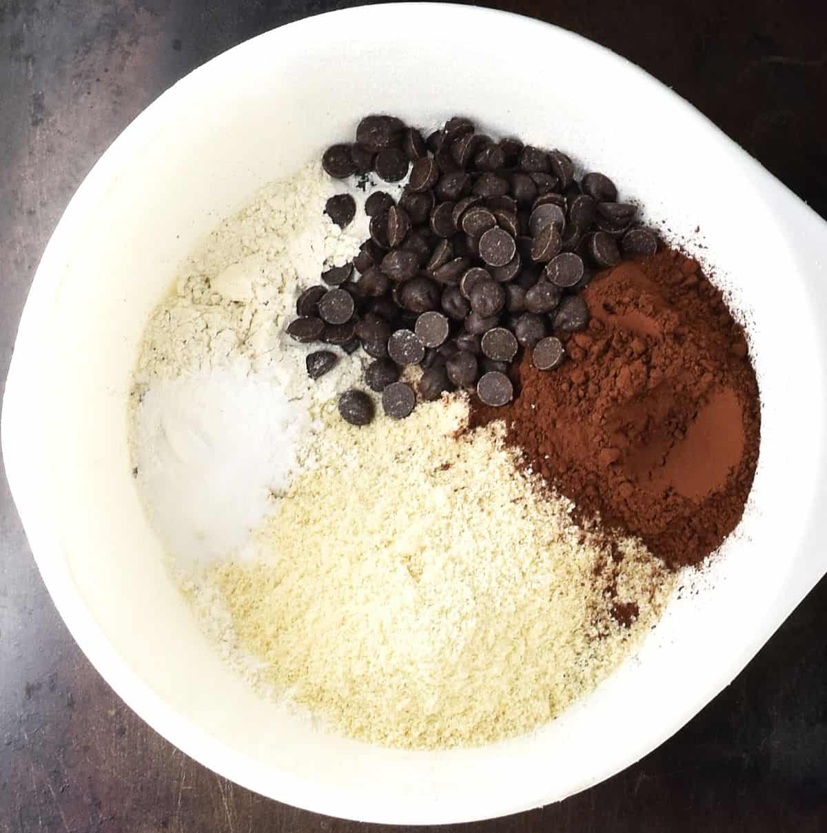 Top down view of dry mixture for beet and chocolate muffins in white bowl.