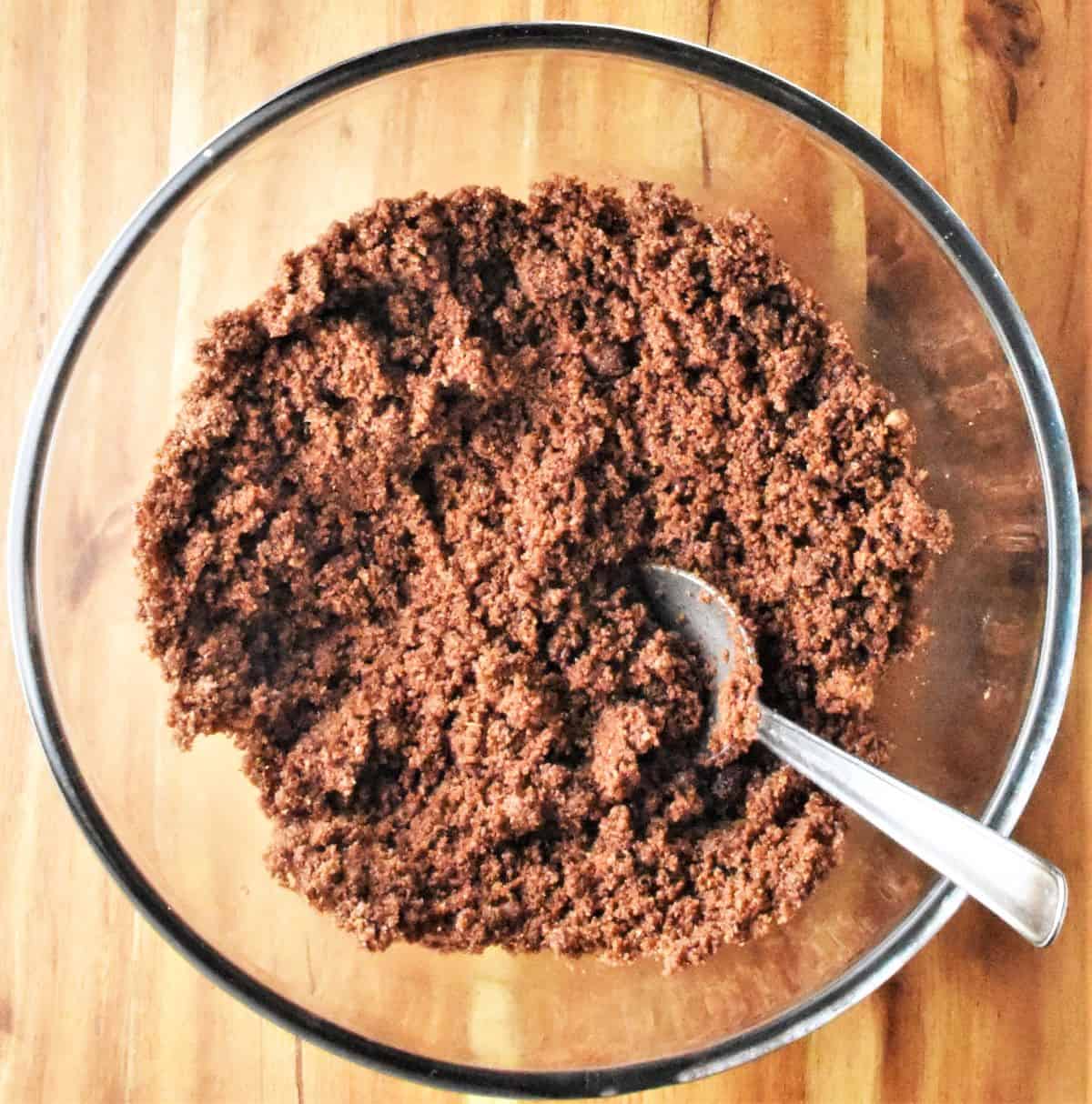 Graham crumb mixture with spoon in bowl.