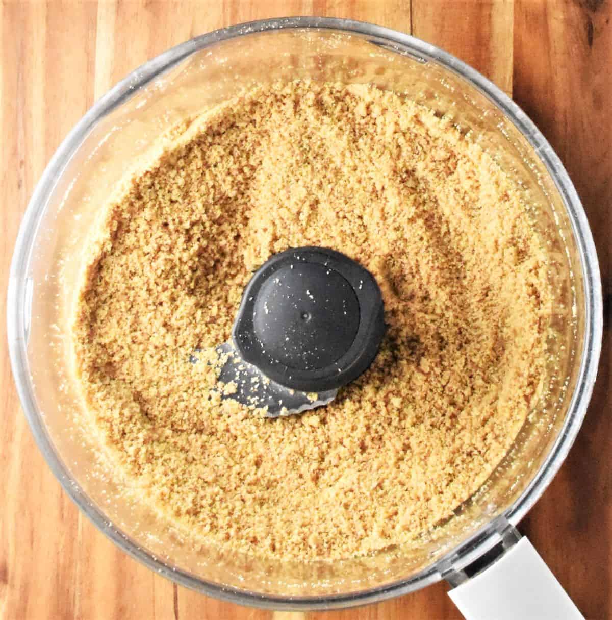 Top down view of biscuit crumb mixture in food processor.