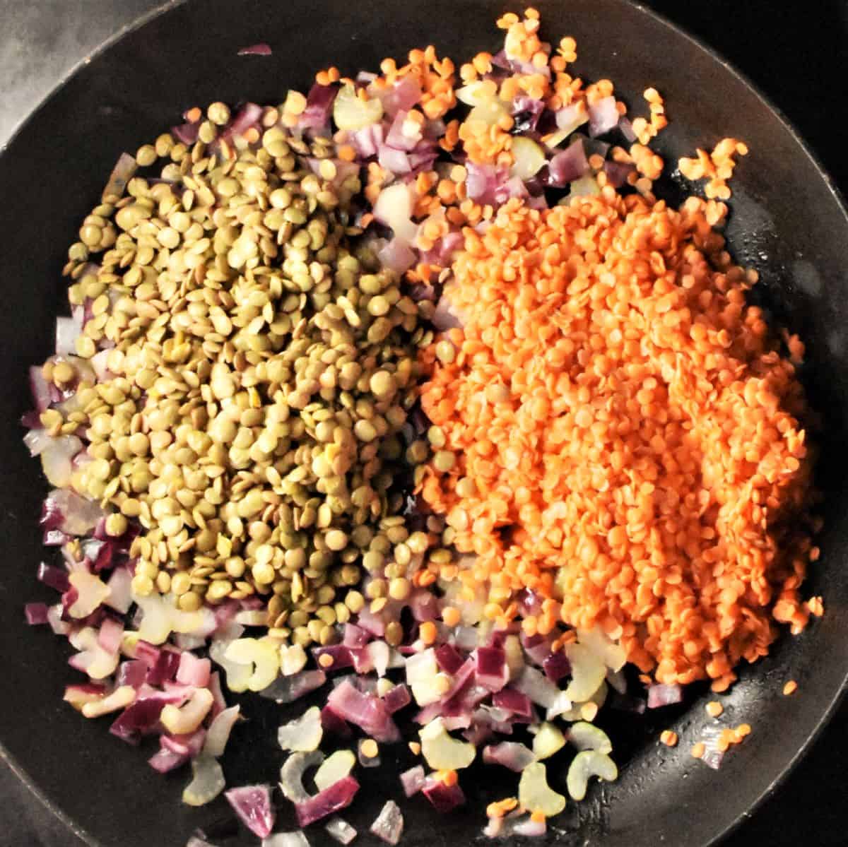 Red and green lentils in pan with red onion.