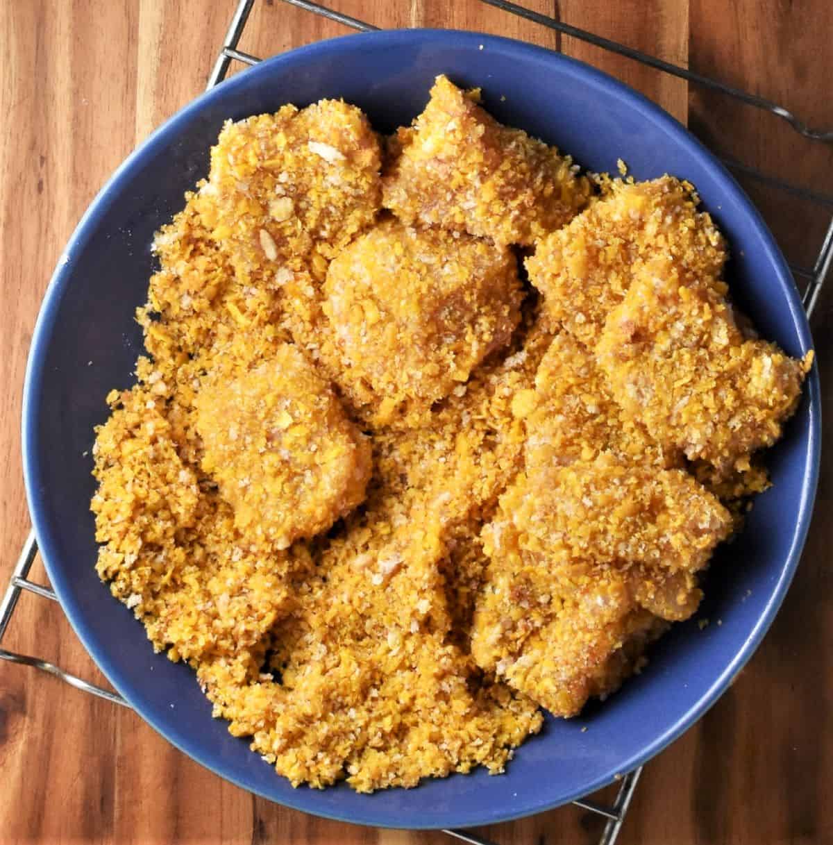 Coating chicken pieces in cornflake mixture.