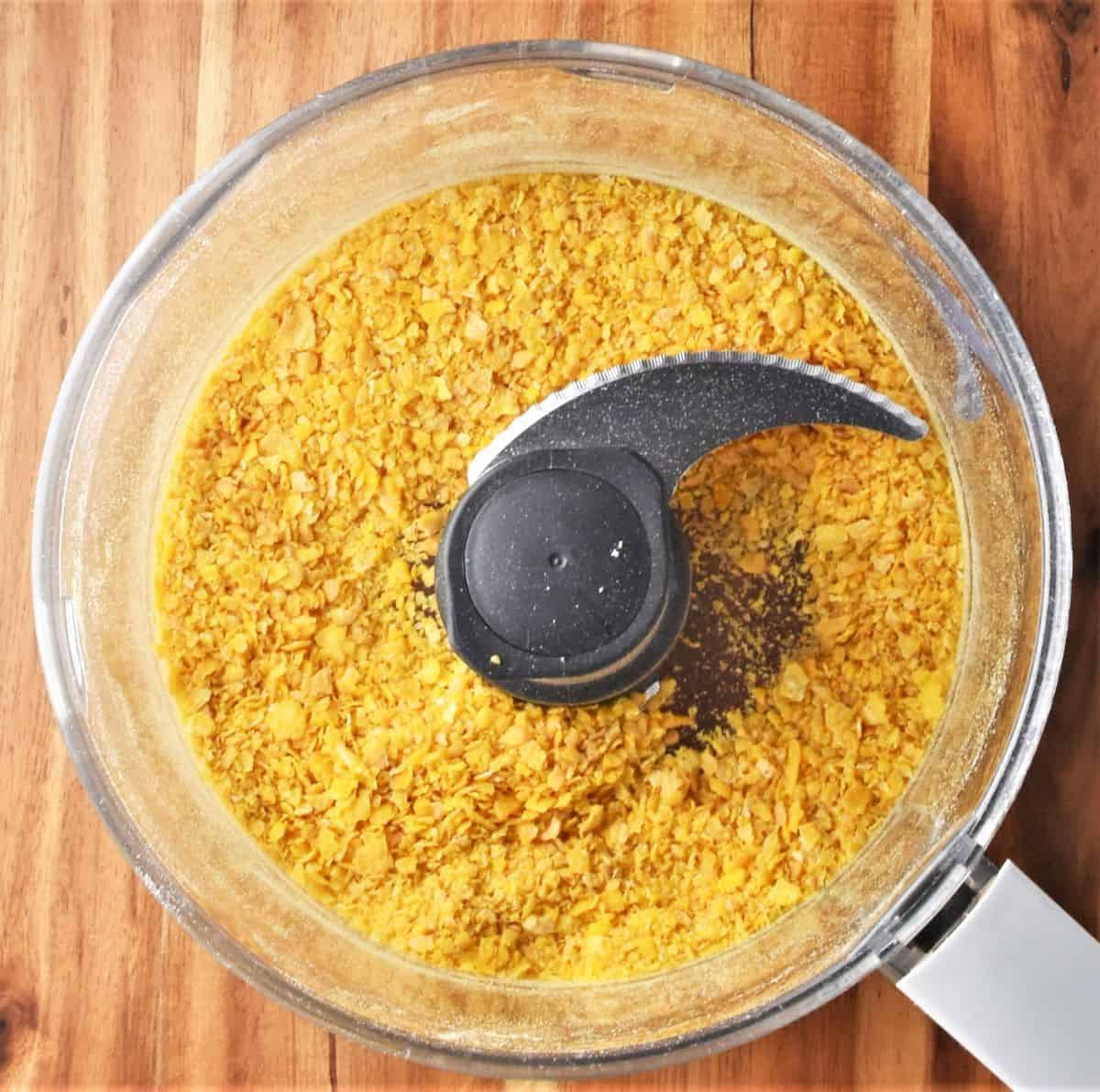 Cornflake crumb in food processor bowl.