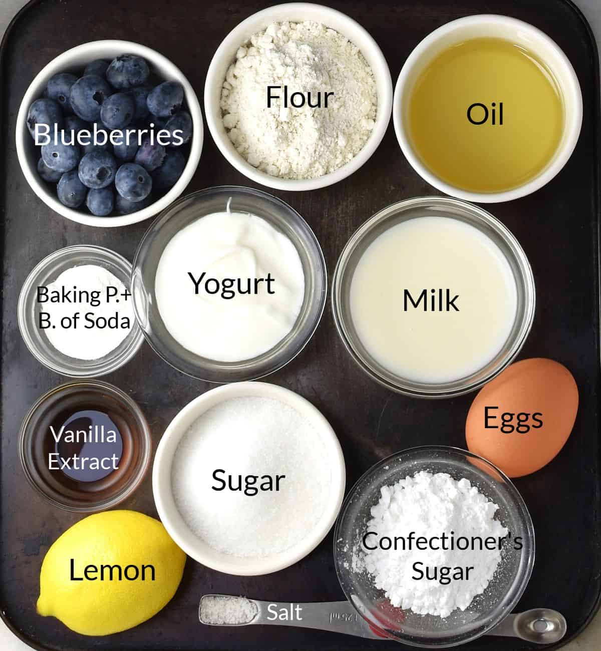 Top down view of ingredients for making fresh blueberry cake in individual dishes.