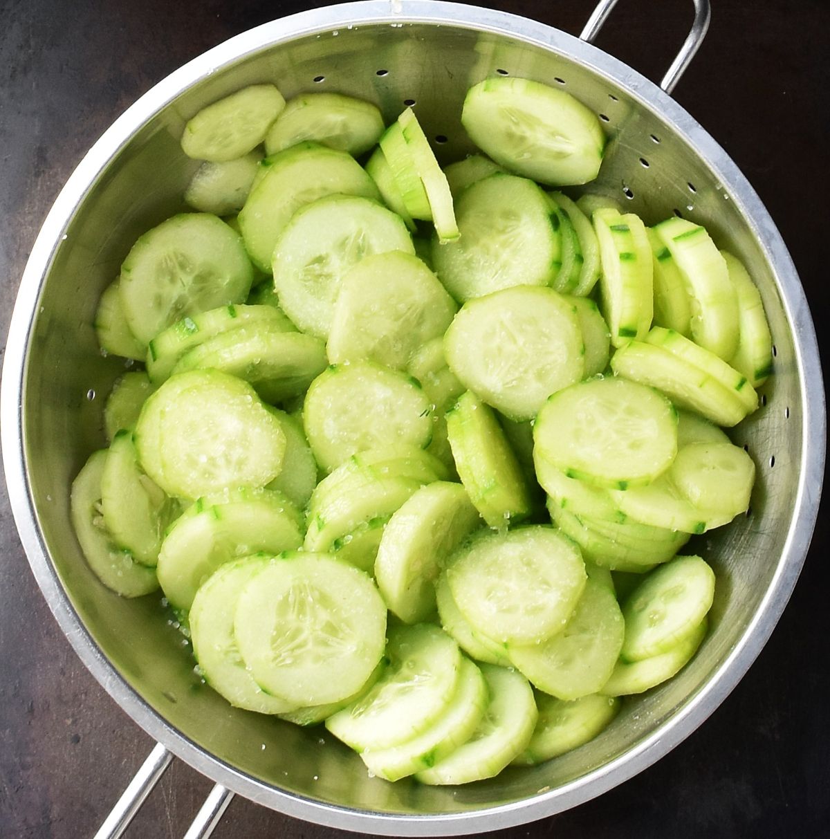 Cucumber slices in metal strainer.