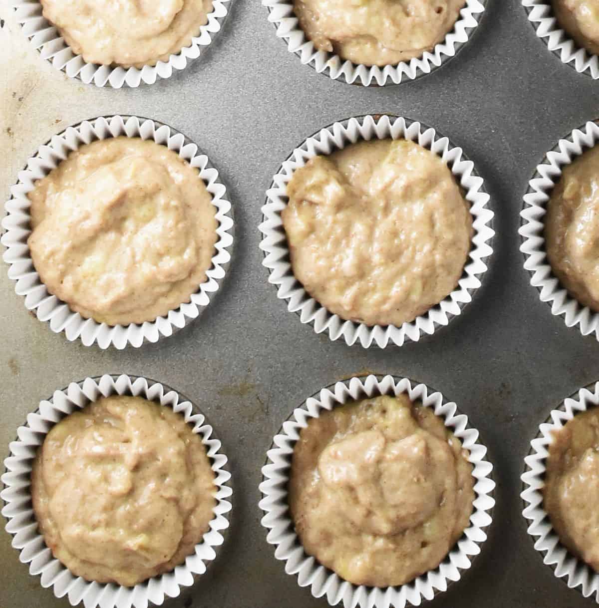 Top down view of banana buttermilk muffin batter in muffin cases.
