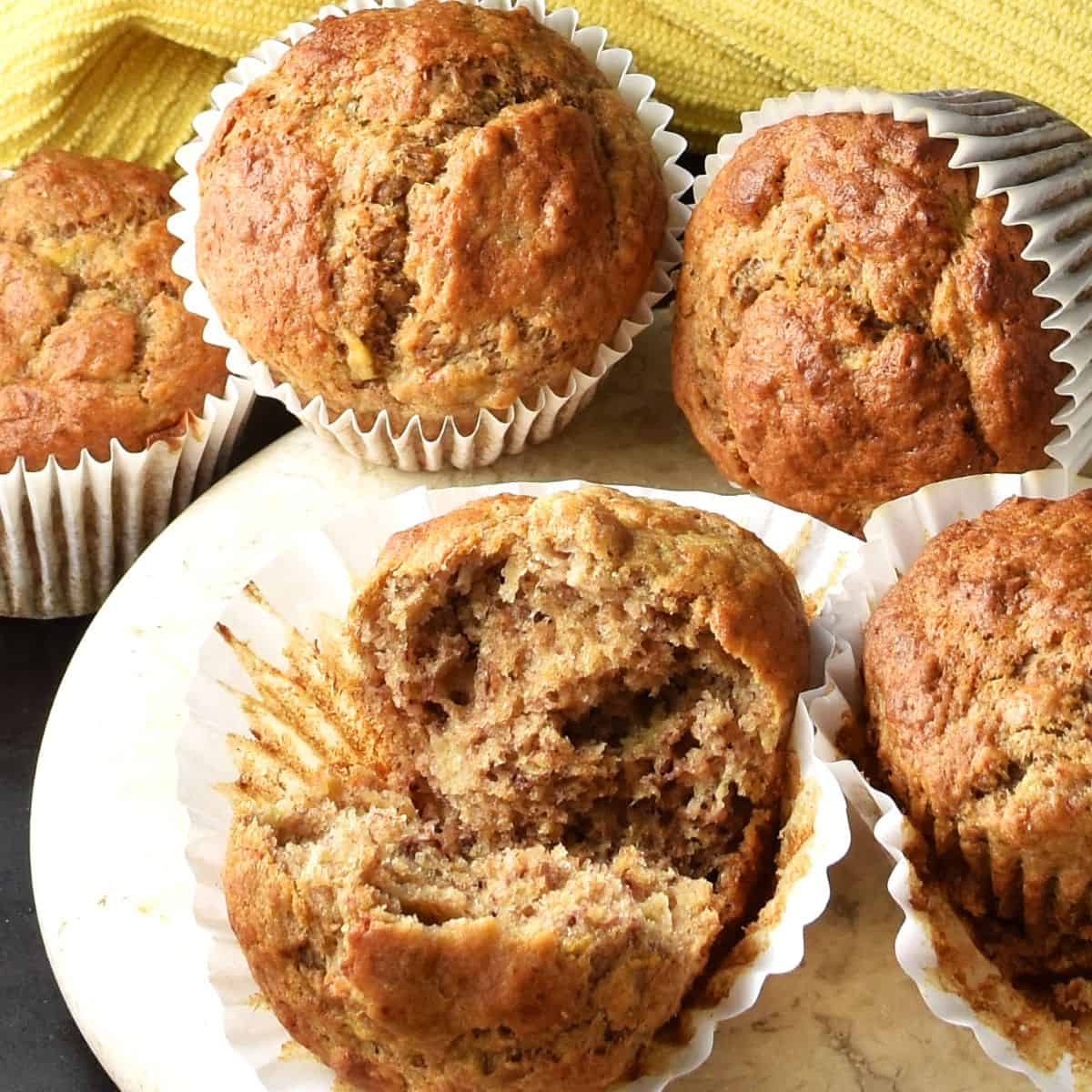 Close-up view of buttermilk banana muffins with yellow cloth in background.