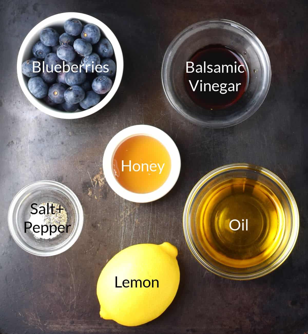 Top down view of ingredients for making blueberry vinaigrette dressing in individual dishes.