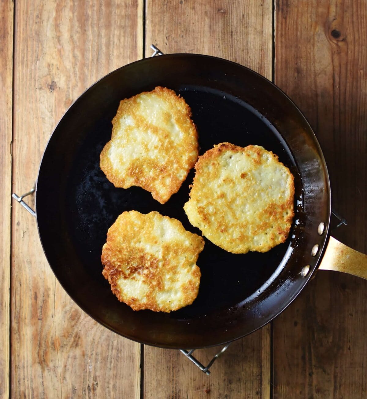 3 crispy pancakes in skillet.