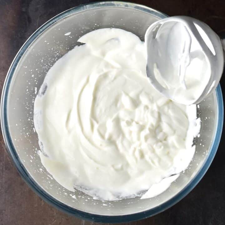Creamy dressing with blender end piece in glass bowl.