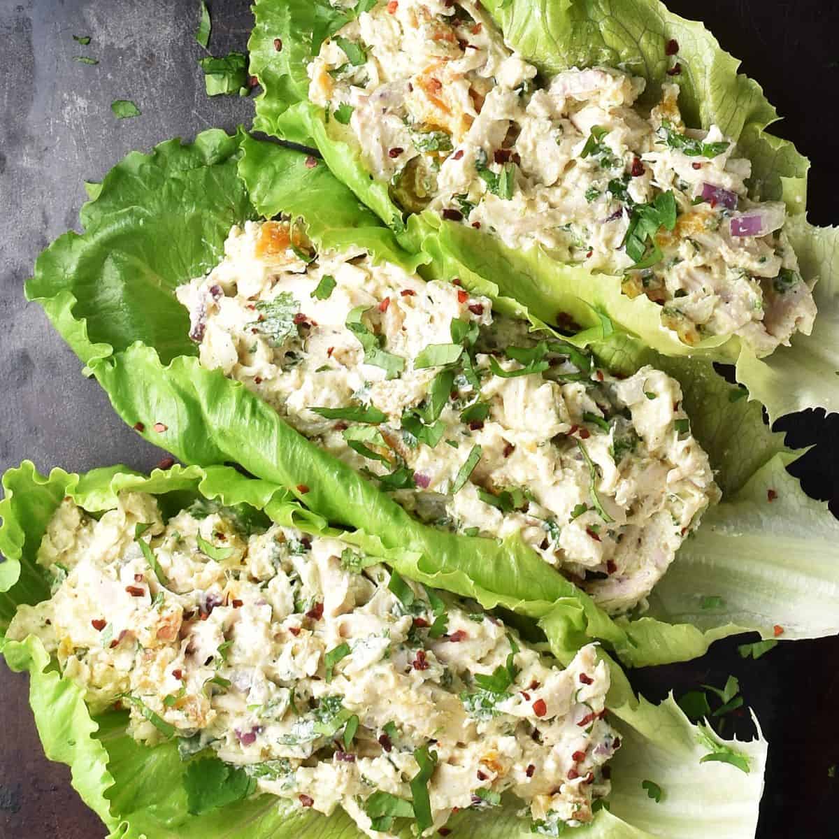 Top down view of high protein chicken salad in lettuce leaves.