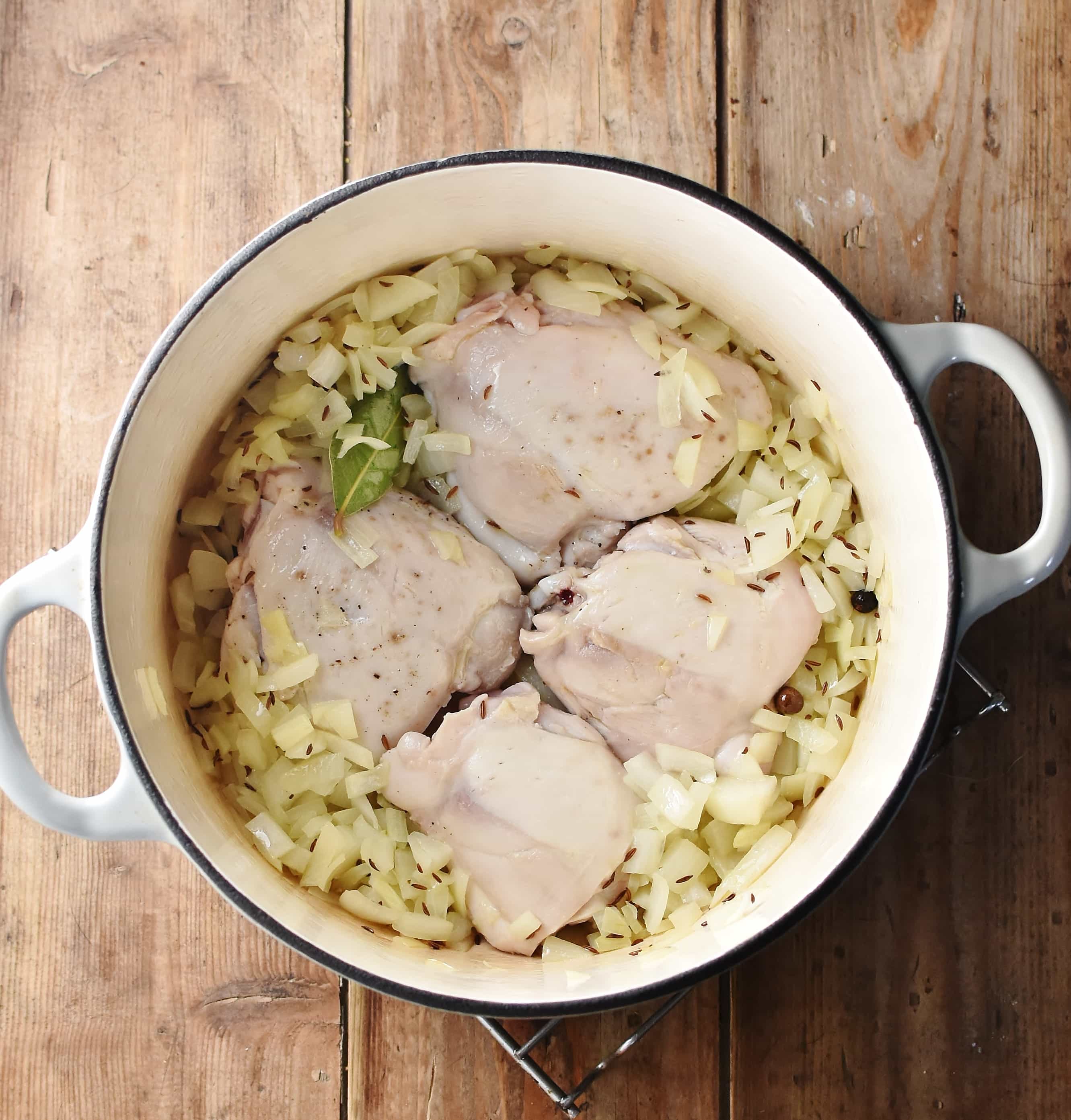 4 chicken pieces and chopped onions in large white pot.