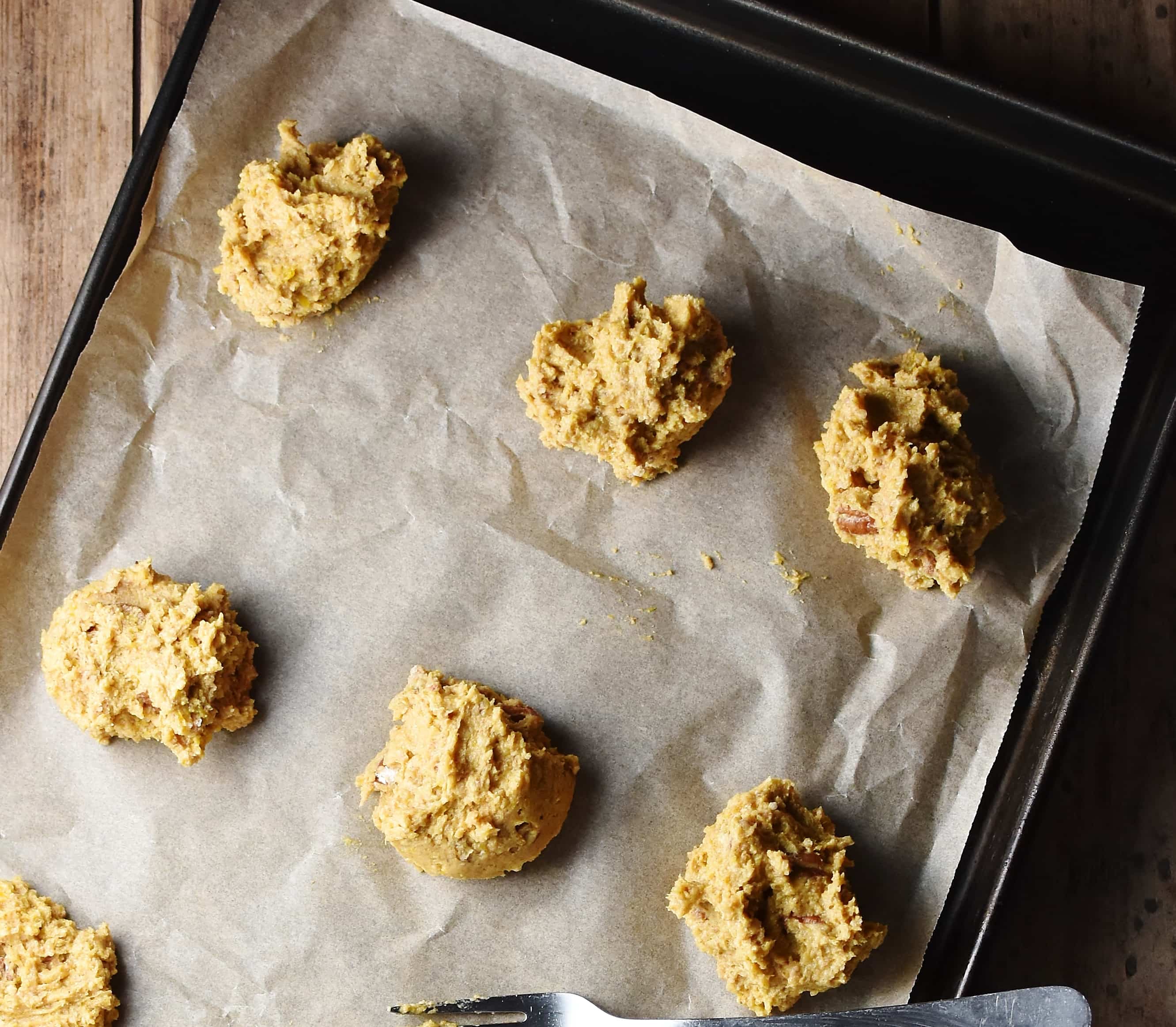 Cookie dough balls on top of paper.