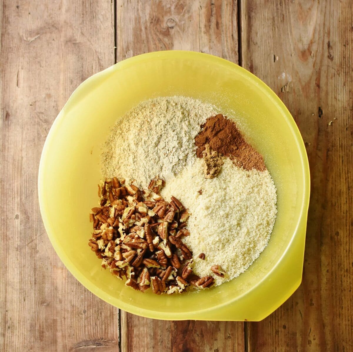 Flour, spices and chopped pecans in large yellow bowl.
