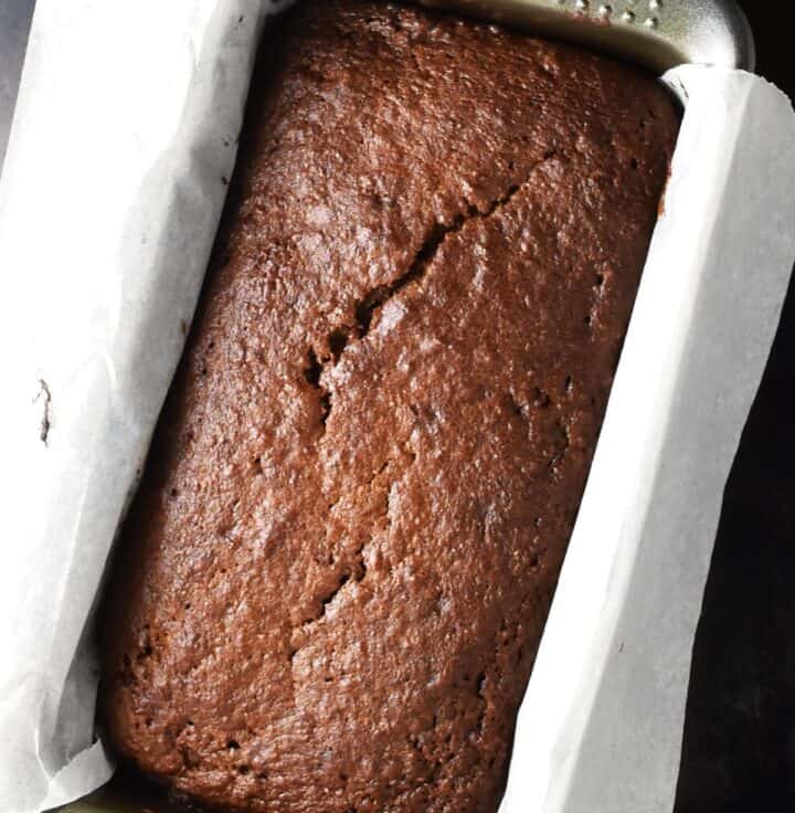 Top down view of baked persimmon bread in pan lined with parchment.