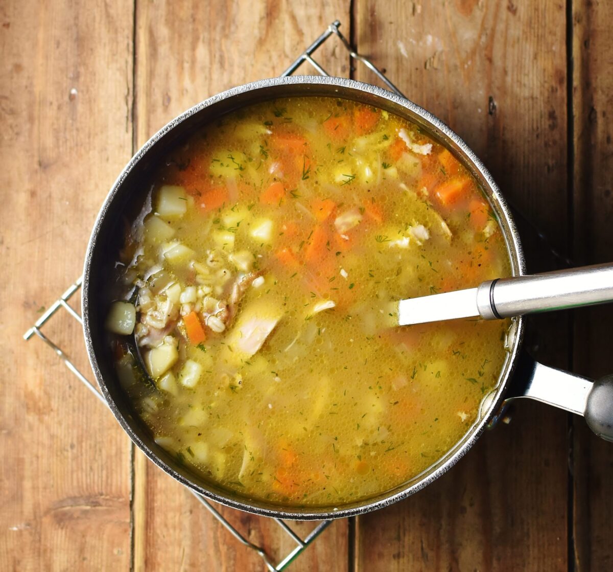 Krupnik soup in large pot with ladle.