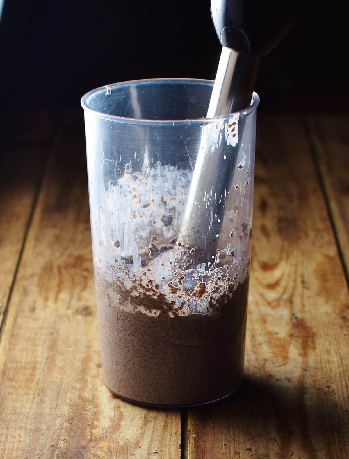 Creamy poppy seed mixture with end of stick blender in tall cup.