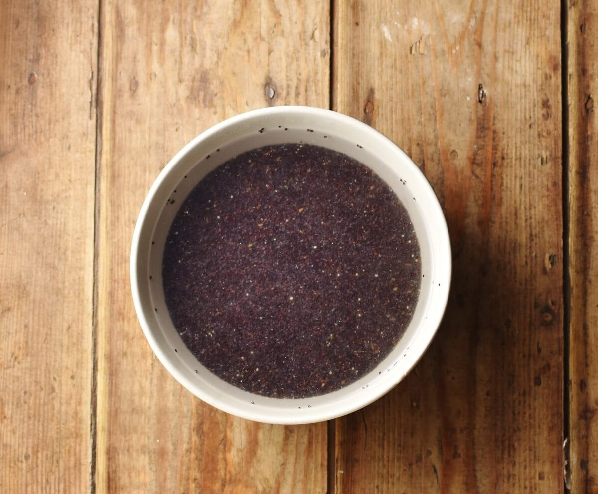 Poppy seeds with water in white bowl.