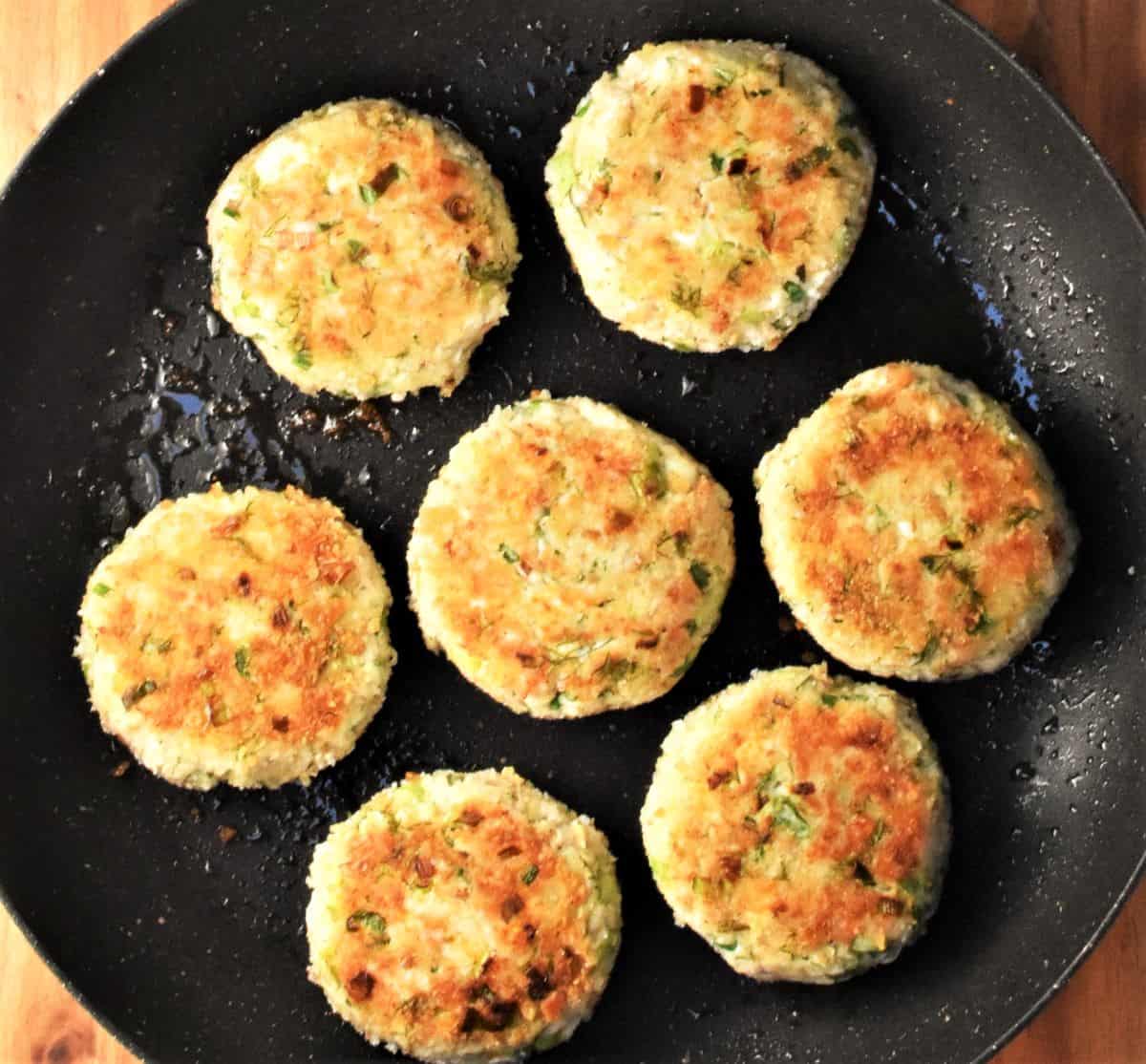 7 bready leftover turkey cakes in frying pan.