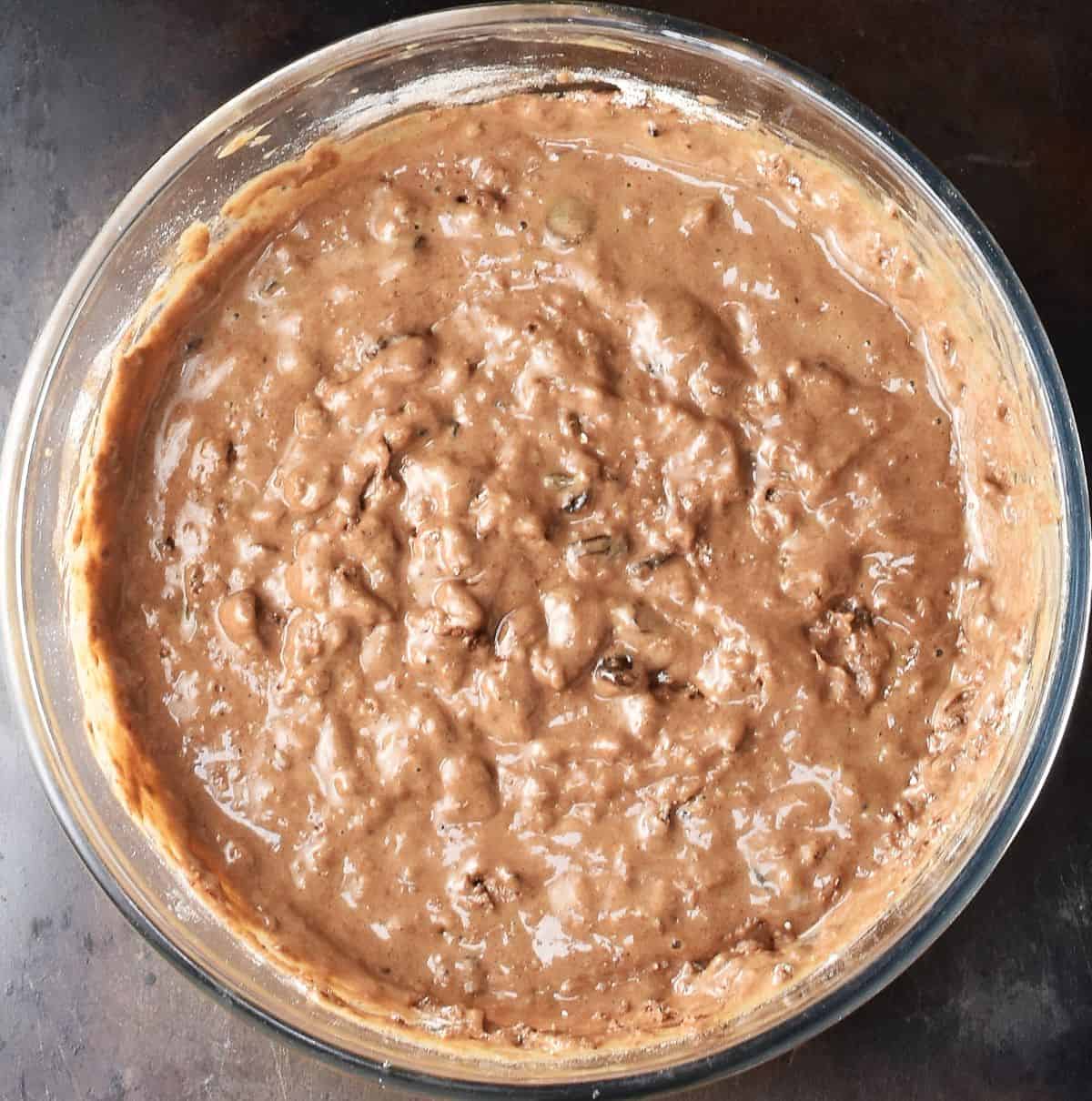 Lumpy batter for healthy gingerbread muffins in glass bowl.