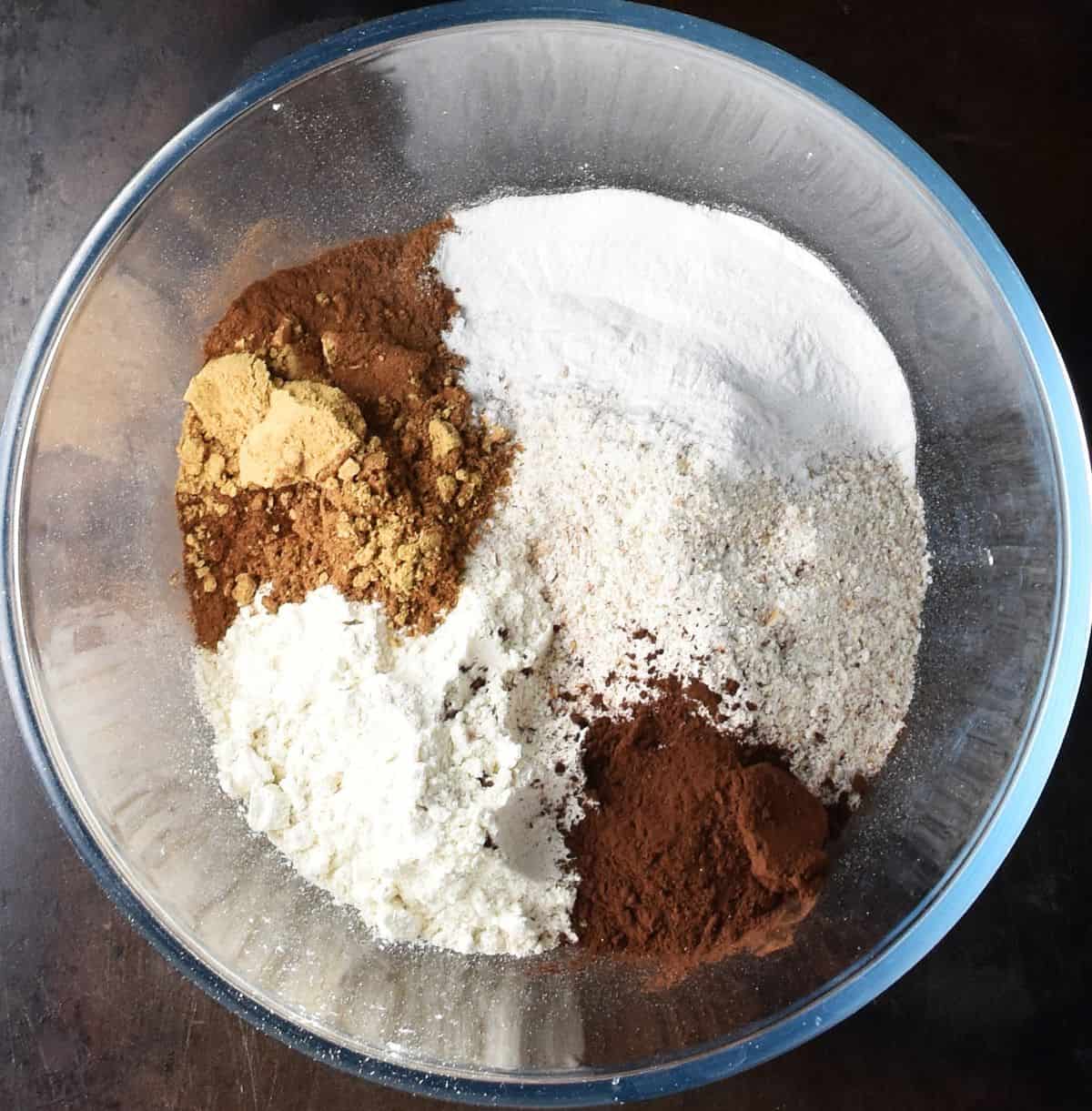 Dry ingredients for gingerbread muffins in glass bowl.