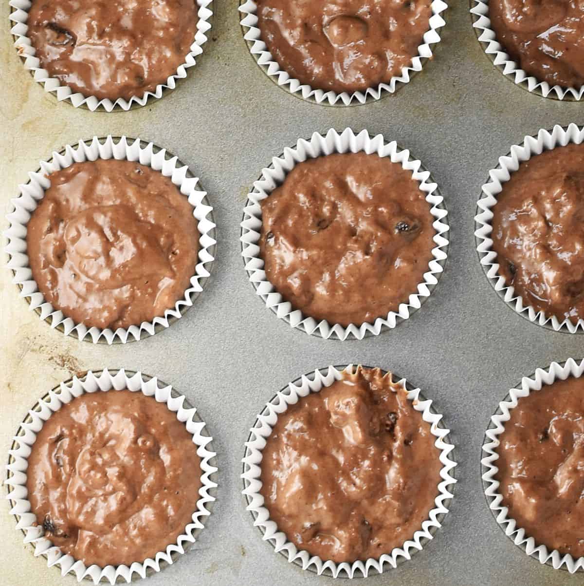 Top down view of gingerbread muffin batter in paper cases.
