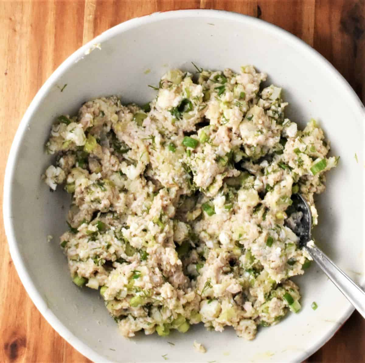Turkey potato cake mixture in large bowl with spoon.