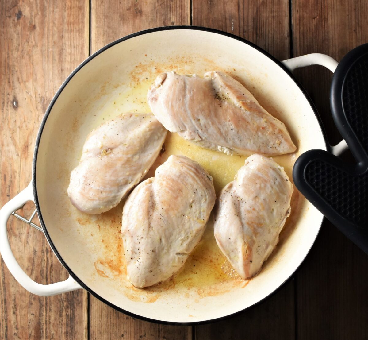 4 chicken breasts in large shallow white pan.