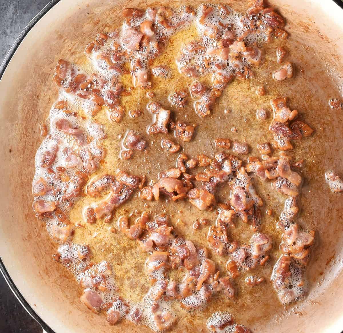 Crispy bacon in large, white skillet.