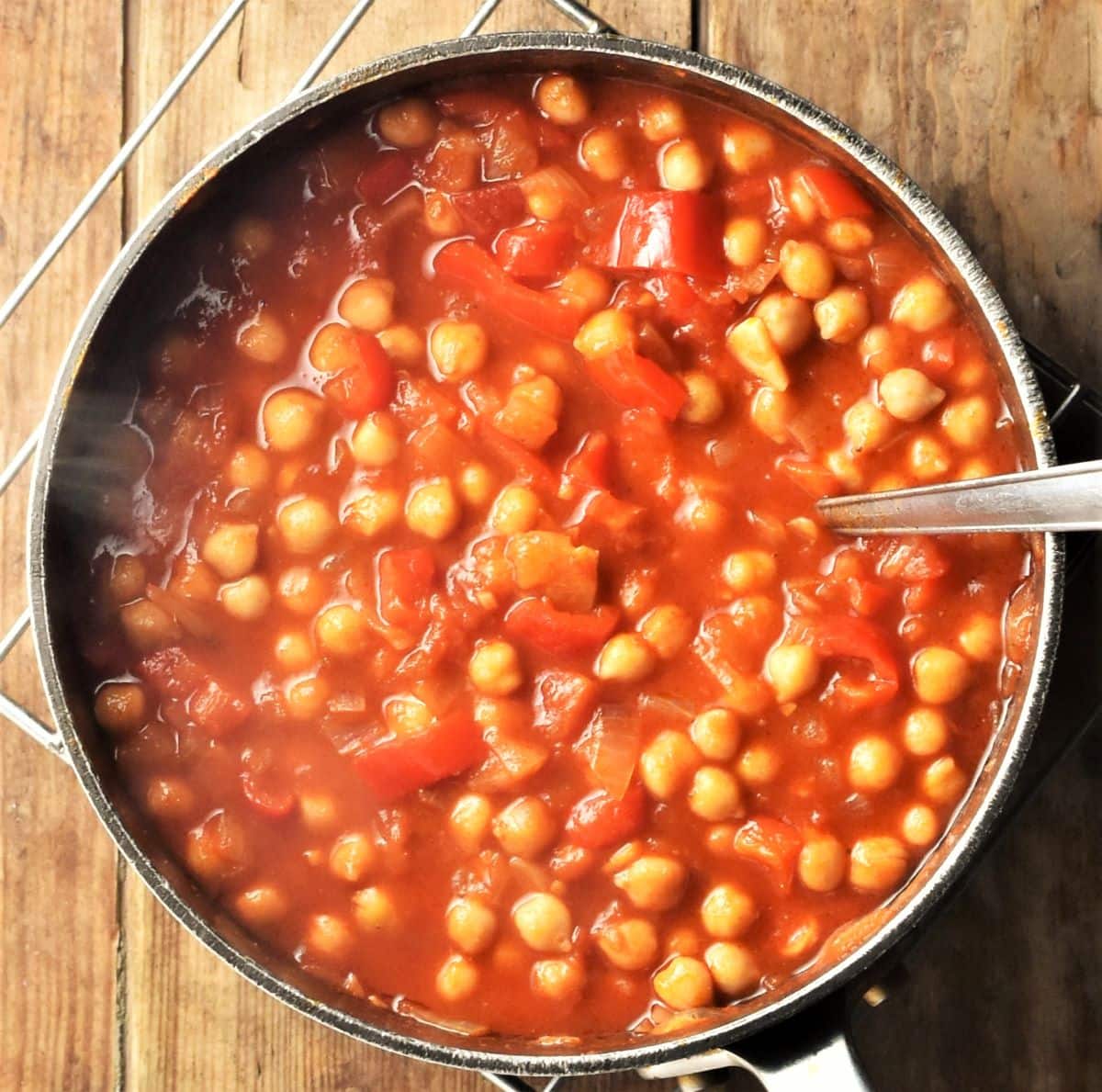 Chickpea casserole in pot with spoon.
