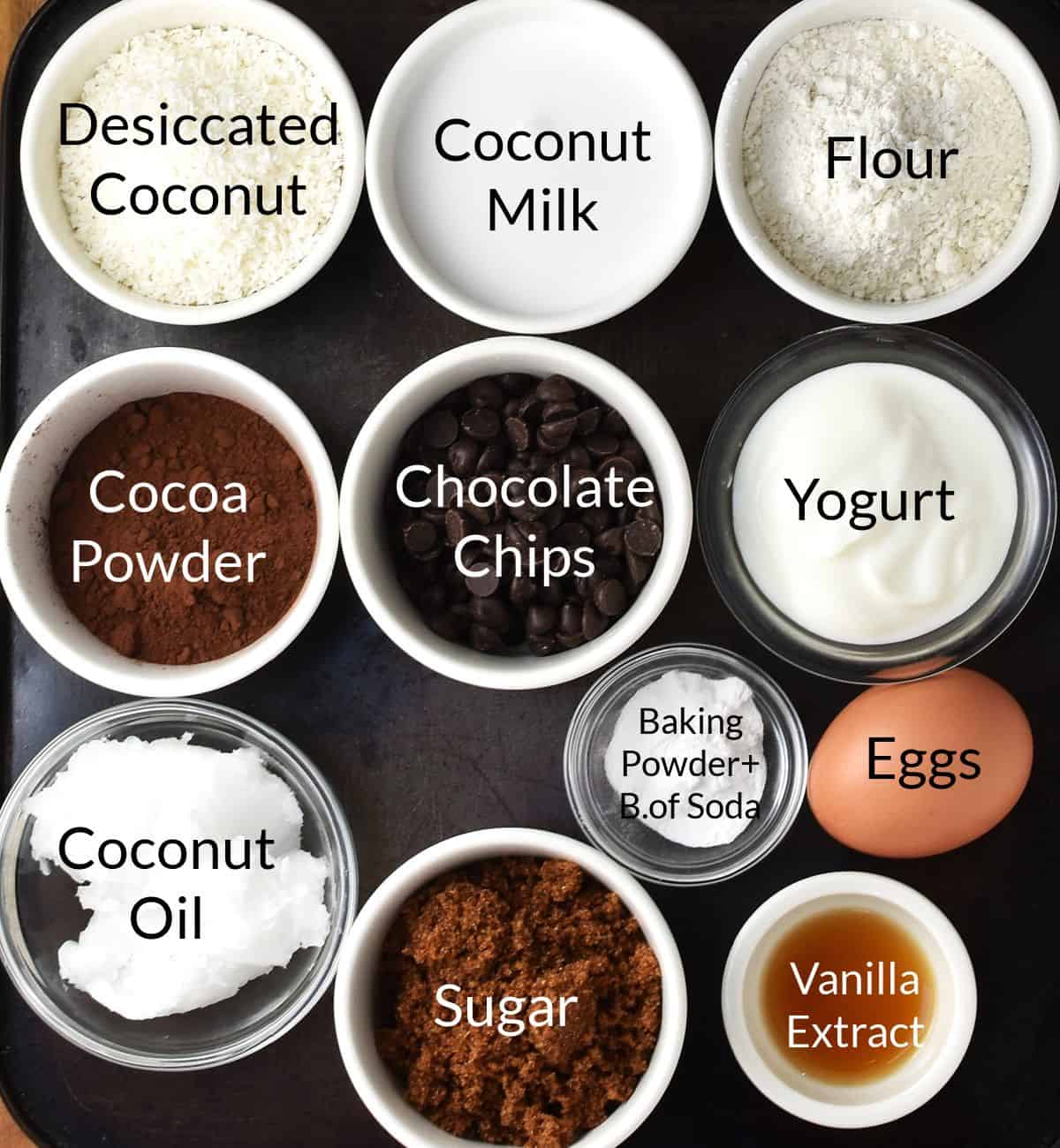 Top down view of ingredients for making chocolate and coconut muffins in individual dishes.