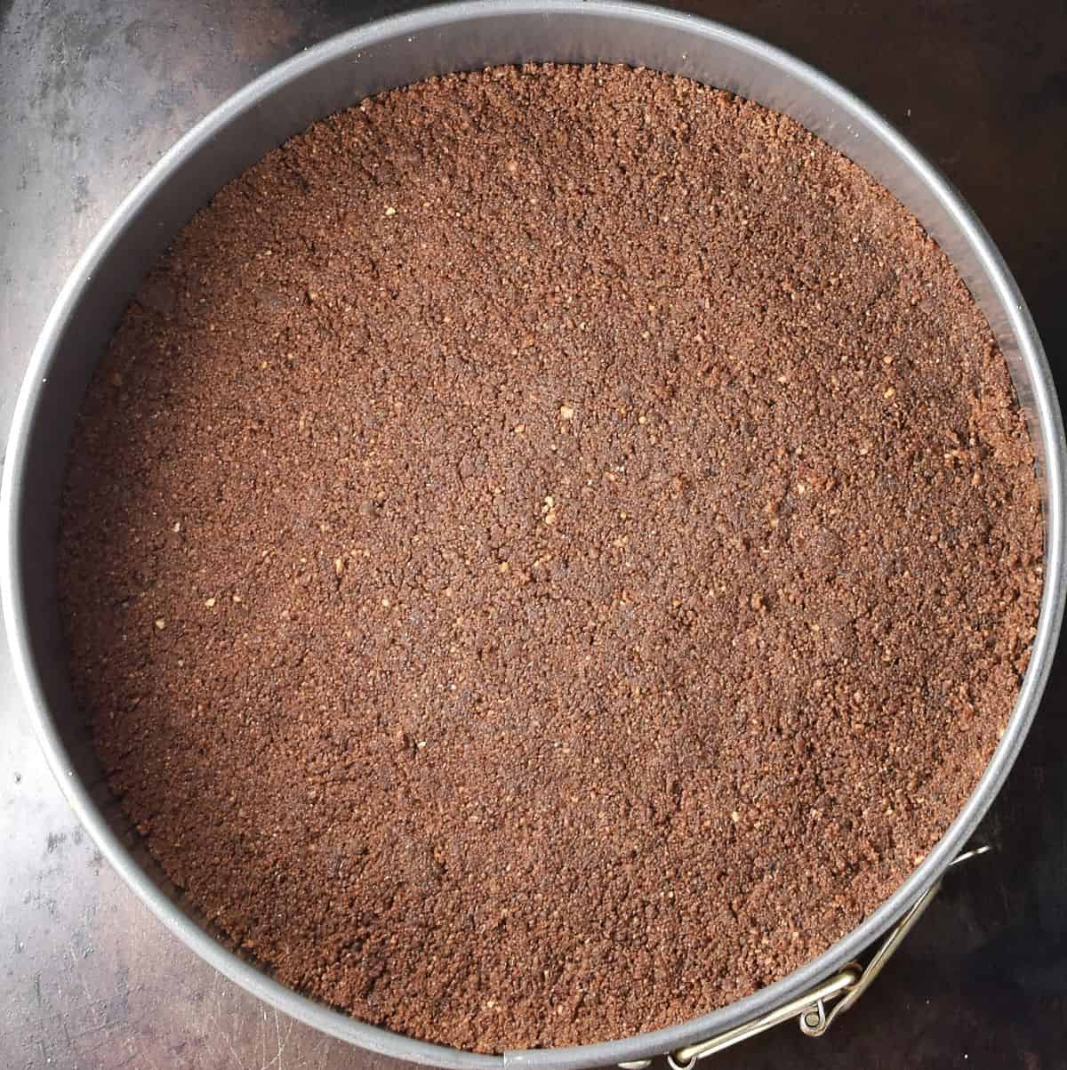 Top down view of cheesecake crust in pan.