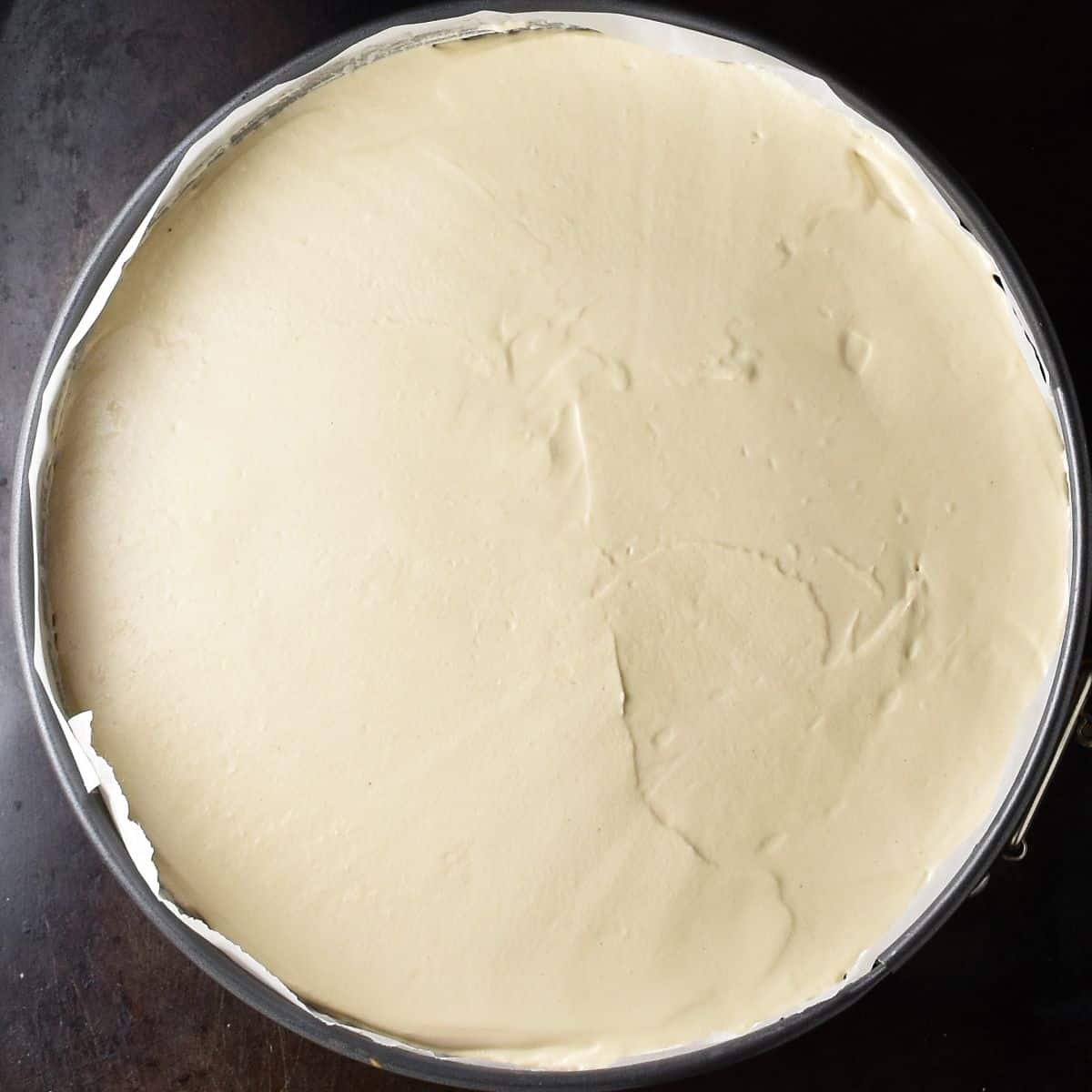 Top down view of coffee cheesecake in springform pan.