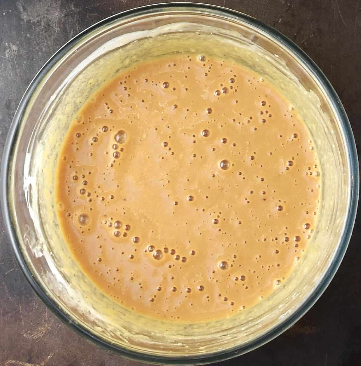Coconut chocolate muffin wet mixture in glass bowl.