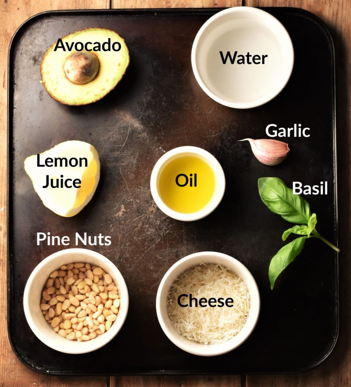 Avocado pesto sauce ingredients in individual dishes.