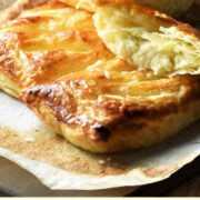Side view of cheese and onion pasties on top of paper.