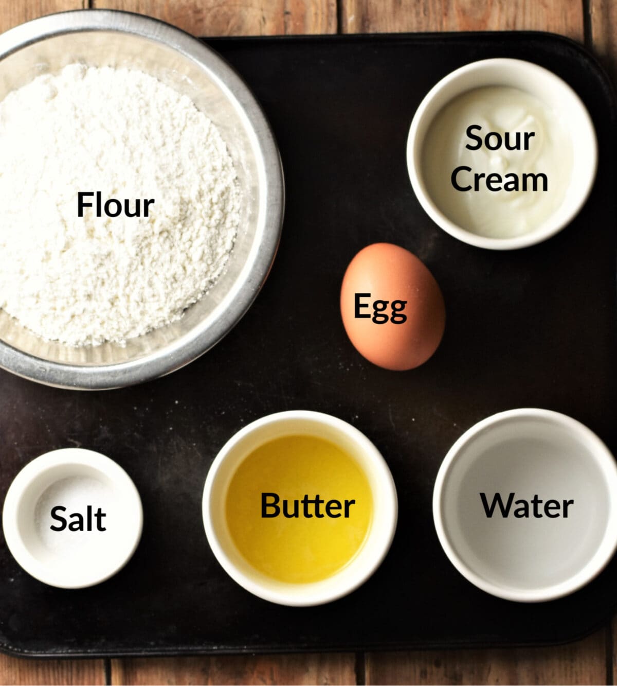 Pierogies dough ingredients in separate dishes.