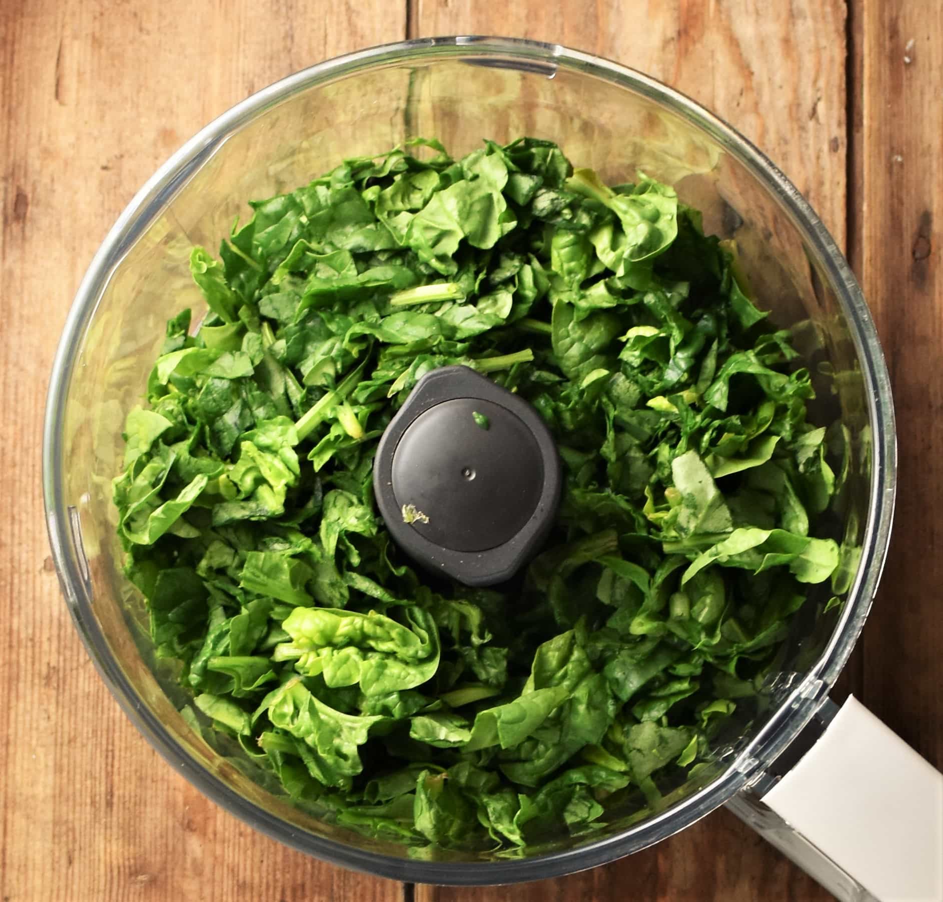 Chopped fresh spinach in blender bowl.
