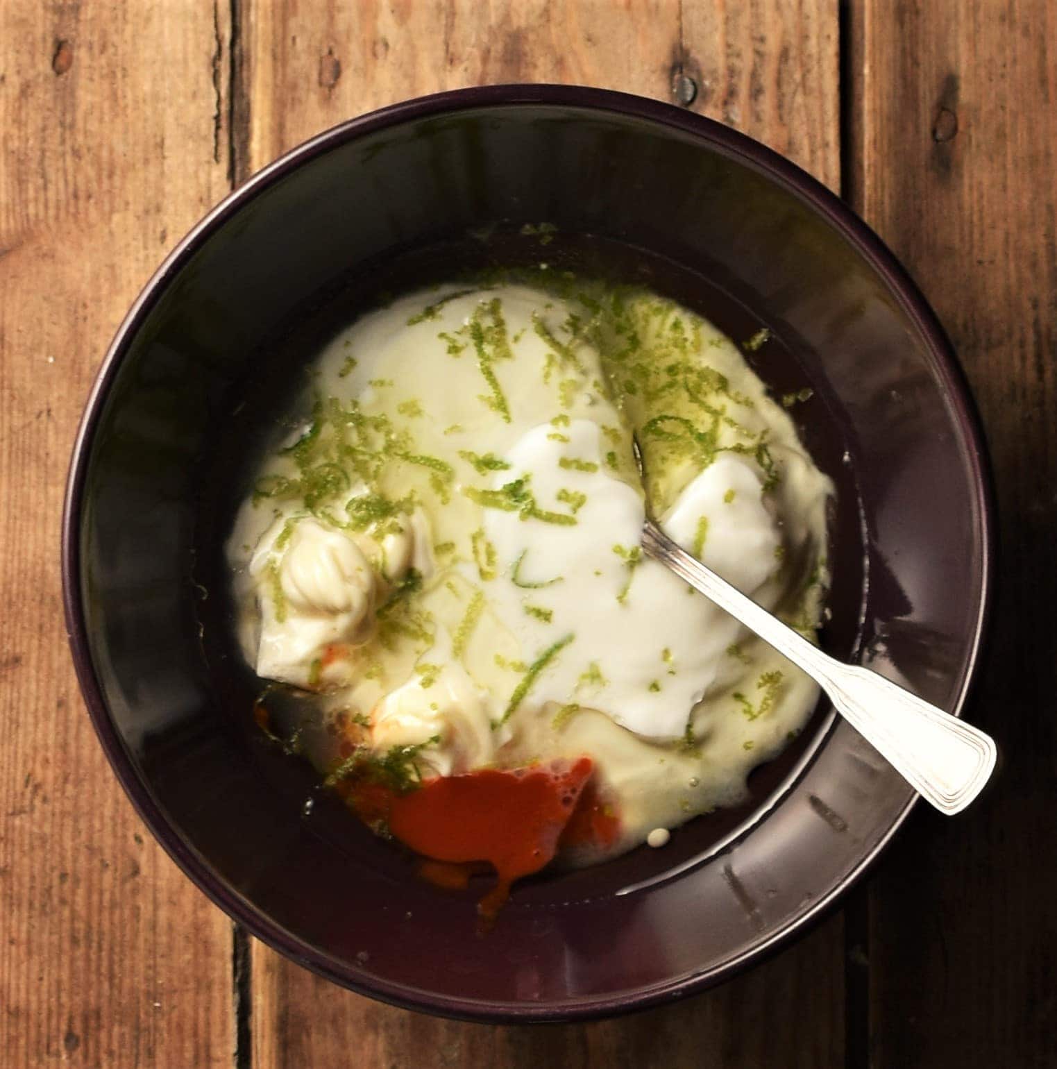 Creamy dressing ingredients for fish tacos in bowl.