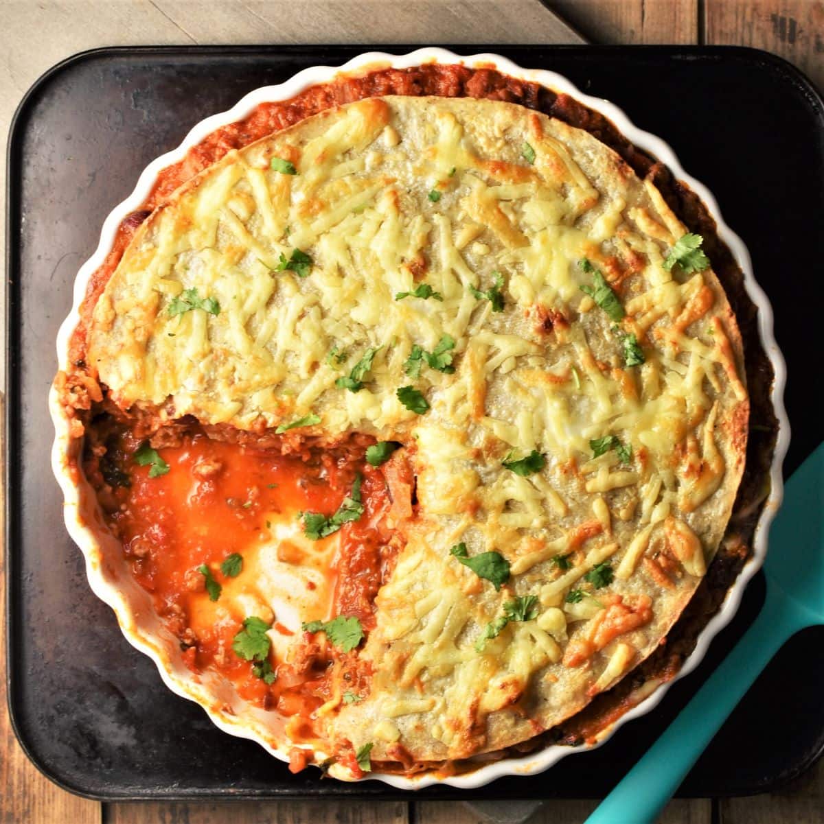 Cut tortilla bake in pie dish with sauce visible.