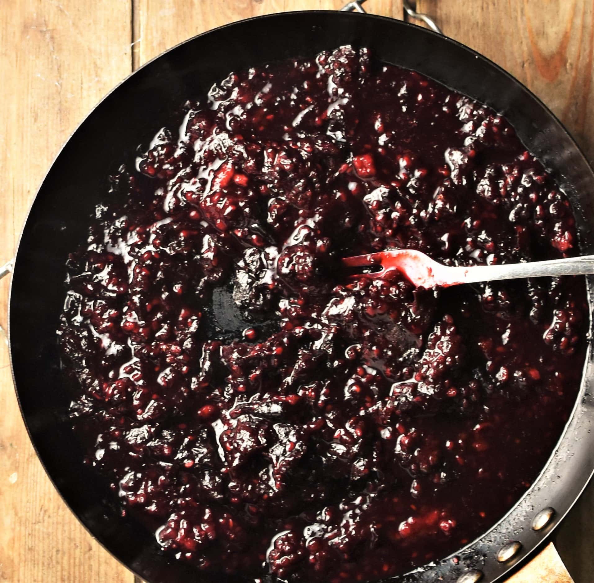Cooking fruit mixture in large pan with fork.